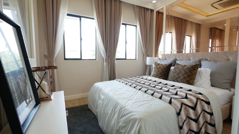 Mala spavaća soba sa velikim prozorima, svetlim zavesama i ogledalima